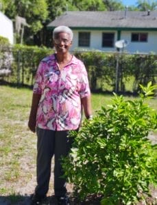 Callie Bryant stands proudly next to her orange tree. 