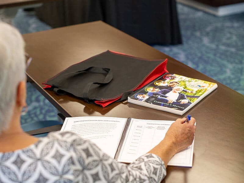 Image of lady taking notes in a caregiver session event