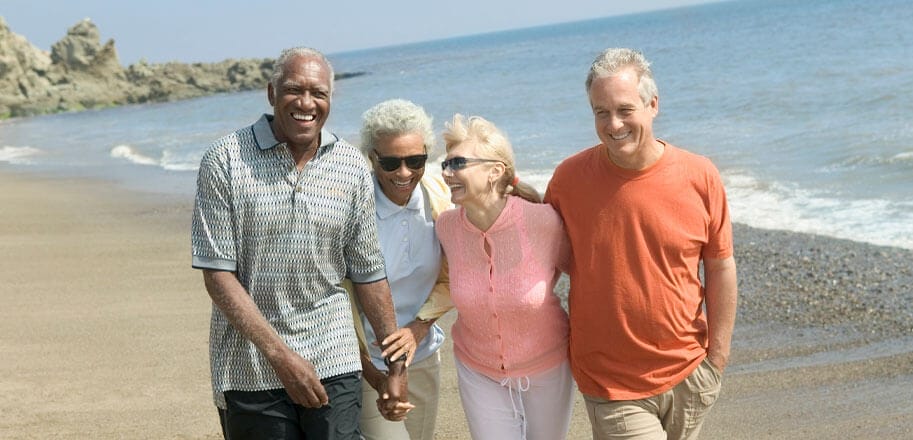 Happy couples walking together on beach