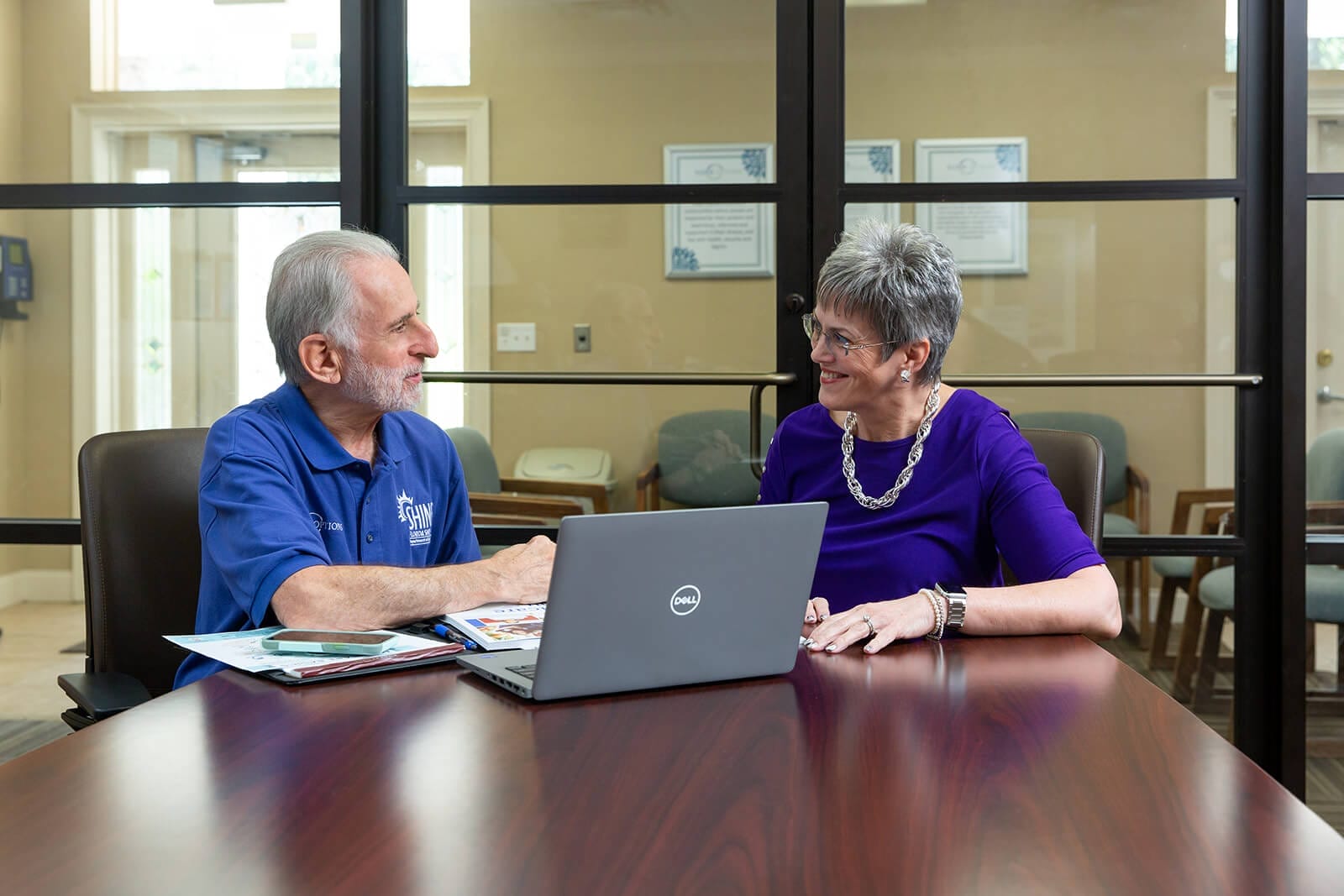 A SHINE volunteer works with a female client at a computer. discussions, medicare, volunteers